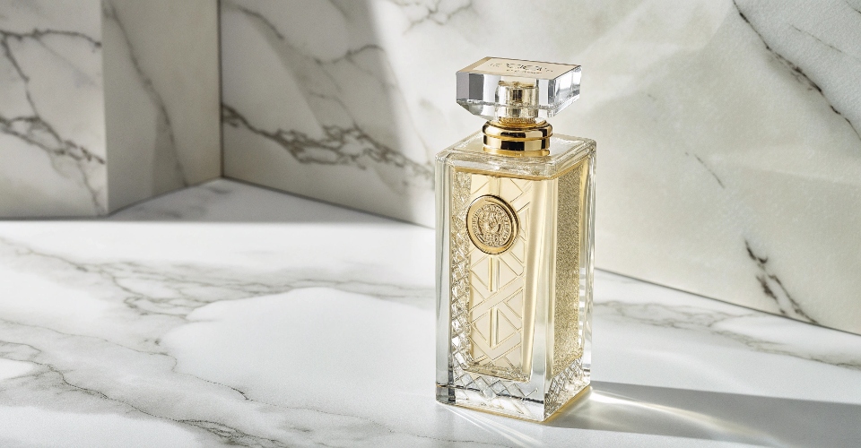 A stunning, high-end refillable perfume bottle standing alone on a marble surface, symbolizing permanent luxury and sustainability.