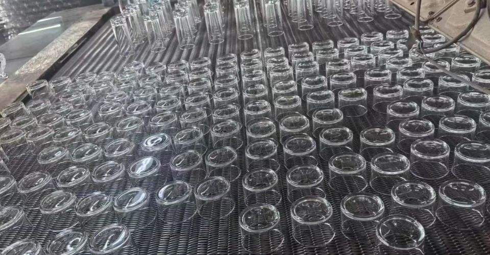 A view of the LOM Glassworks factory production line where glass candle jars are inspected for quality.