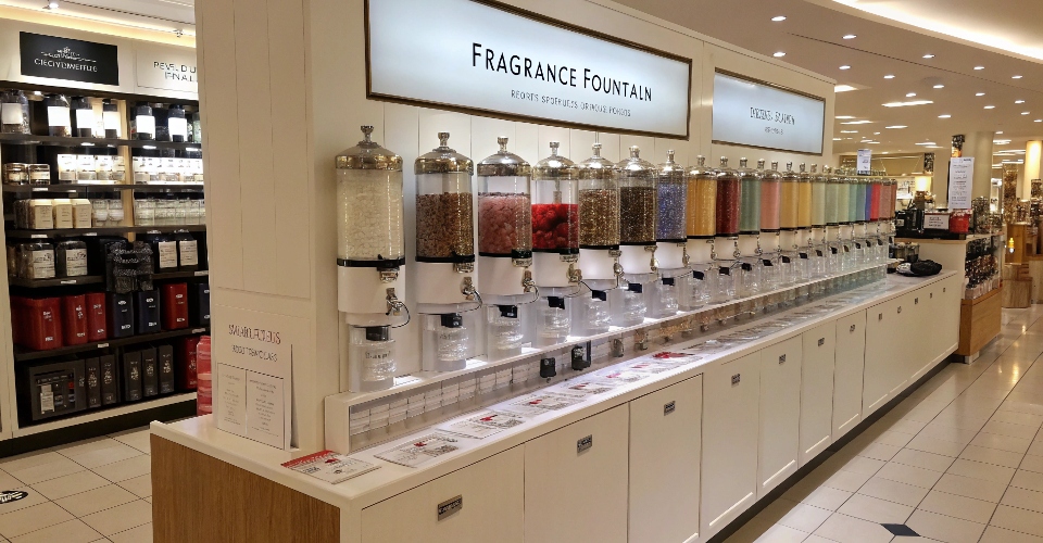 A modern, well-lit in-store perfume refill station, often called a