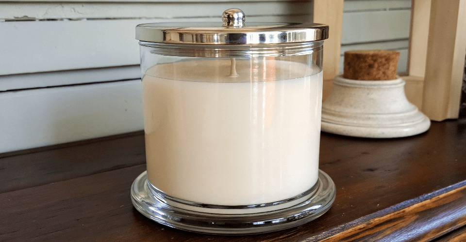A close-up of a high-quality glass candle jar highlighting its thick, sturdy base for better heat distribution.