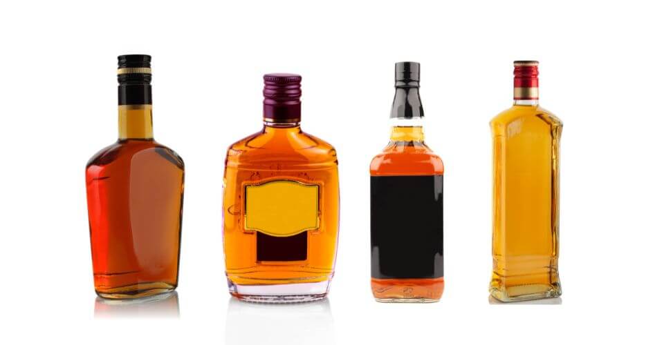 A collection of unique and custom-designed liquor bottles showcasing different shapes and embossed logos.