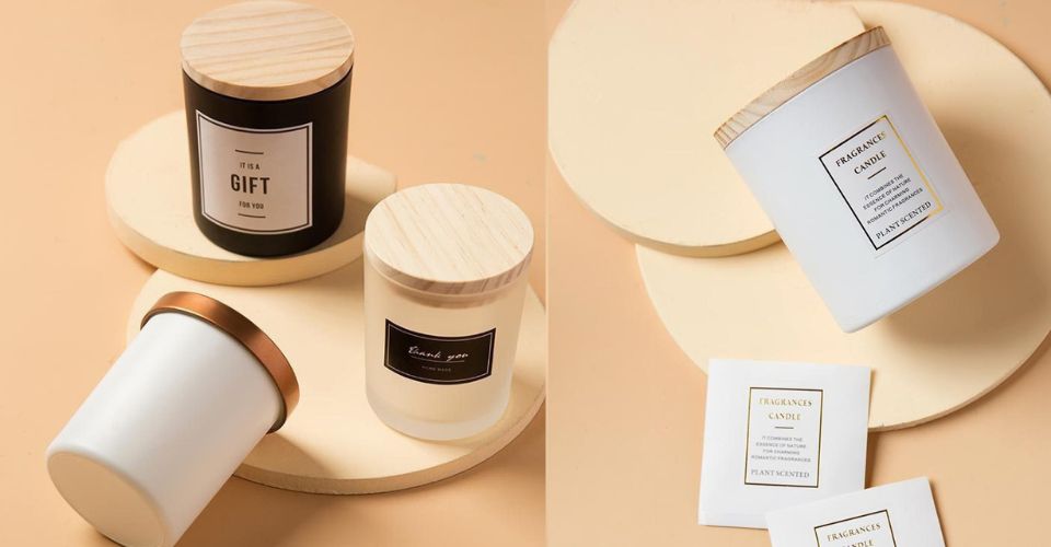 A stylish 12 ounce candle jar with a wooden lid in black and white with label next to books, used as home decor.
